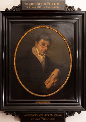 Geschilderd portret in een ovaal van een man met een ronde bril, donkere jas en hoge witte halsdoek, met zijn hand rustend op de voorgrond. Op het plaatje boven de zwarte lijst: François Joseph Pfeiffer Jr, 5 October 1778 – 4 Augustus 1835; op het plaatje eronder: Aangeboden door Jan Maandag en zijn vrienden.