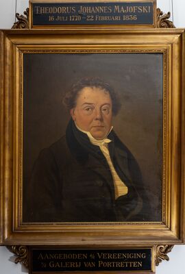Geschilderd portret van een man met krullend haar, in een donkere jas met opstaande kraag over een geel vest en een witte halsdoek. Op het plaatje boven de lijst: Theodorus Johannes Majofski, 16 Juli 1770 – 22 Februari 1836; eronder: Aangeboden d/d Vereeniging v/d Galerij van Portretten.