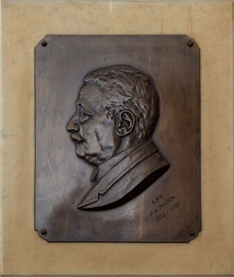 Bronzen plaquette op een marmeren plaat: het hoofd van een oudere man in profiel naar links, met een hoge boord en een jas met revers. In de bronzen plaat gegraveerd: Aan P.A. Morin, 1838 – 1888.