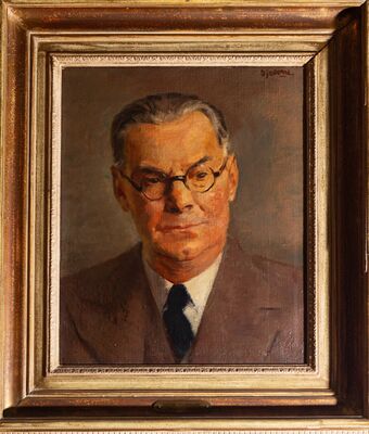 Geschilderd portret van een man met grijzend haar en een ronde bril, in een bruin colbert met een wit overhemd en een donkere das. Rechtsboven gesigneerd: Sjollema. Op het plaatje onderaan de lijst: Oscar Tourniaire.