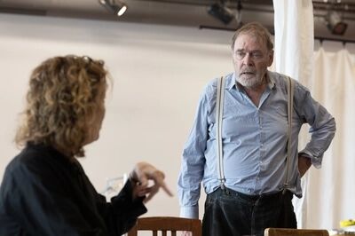 Een man staat met zijn hand op zijn heup en kijkt naar zijn vrouw.