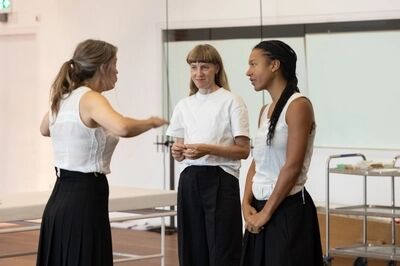 Een vrouw gebaart met haar handen terwijl ze iets uitlegt aan twee andere vrouwen.