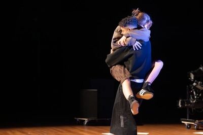 Een persoon springt bij de ander in de armen.
