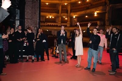 Cast en crew toosten op het podium na de première